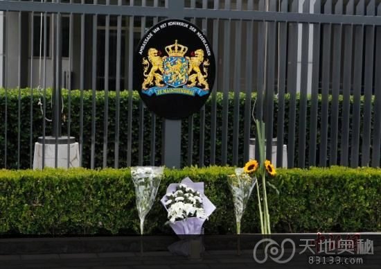 7月18日，民众将鲜花和蜡烛放在北京荷兰驻华大使馆门前，悼念马航MH17事故遇难者。中新社发 刘关关 摄