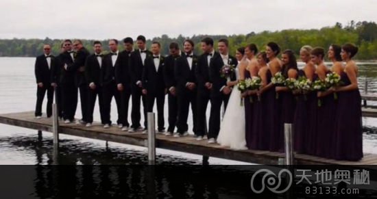 美国新婚夫妇及20名伴郎伴娘站在防波堤上准备合影。（网页截图）