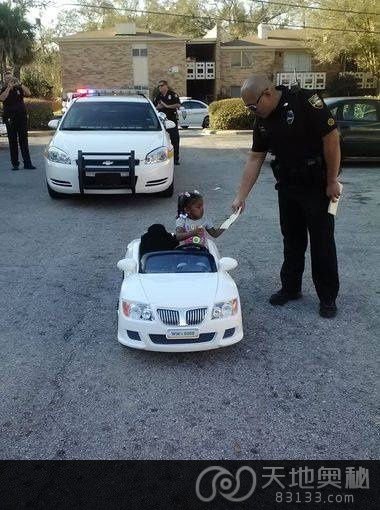 小米夏在自家门前开着玩具车，被警察叔叔“开了罚单”。