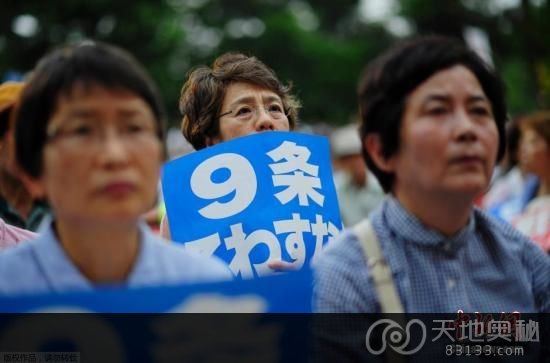 资料图：6月17日晚，约5000名日本民众聚集在东京日比谷公园，举行集会反对安倍内阁解禁集体自卫权。图为日本民众举着“反对战争”“不要破坏（宪法）第九条”等牌子坐在集会现场。