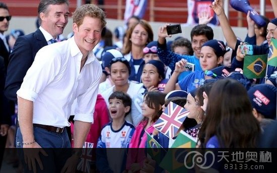 图为哈里王子访问智利期间与小球迷合影。