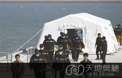 21日，韩国珍岛某港口，救援人员抬着“岁月”号沉没客轮遇难者遗体。截至21日，遇难人数已增至87人。新华社发