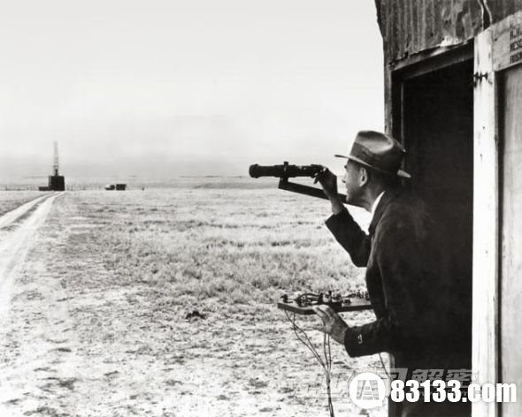 罗伯特-哥达德站在射击控制板一旁，从他的发射控制室观察发射地点